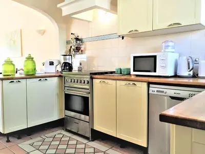 a kitchen with white cabinets and a microwave at Villa Luz Bay w Private Pool in Luz