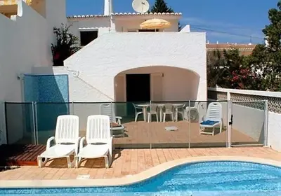 a swimming pool with chairs and a table and a house at Villa Luz Bay w Private Pool in Luz