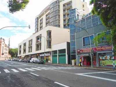 an empty city street with cars parked in front of buildings at Quinta Miramar in Funchal