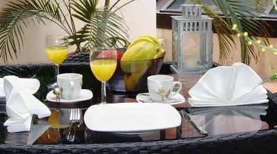 a table with two glasses of orange juice and drinks at Quinta Miramar in Funchal