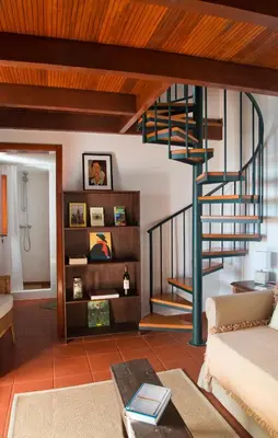 a living room with a spiral staircase in a house at Casa da Manta - Palheiro in Fajã da Ovelha