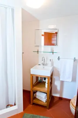 a bathroom with a white sink and a shower at Casa da Manta - Palheiro in Fajã da Ovelha