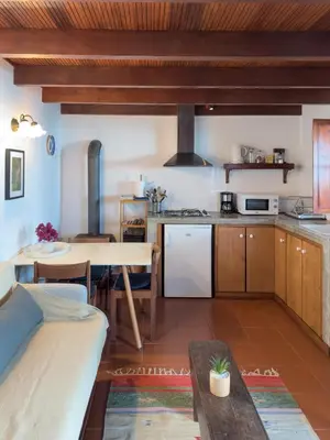 a kitchen with a table and a dining room at Casa da Manta - Palheiro in Fajã da Ovelha