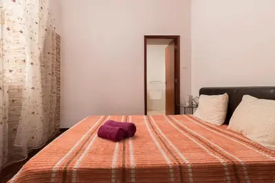 a bed with a purple towel on top of it at CAPTAIN´S HOUSE in Paul do Mar