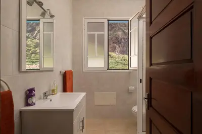 a bathroom with a sink and two windows at CAPTAIN´S HOUSE in Paul do Mar