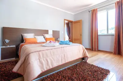 a bedroom with a large bed with orange pillows at Apartment Laranjeiras in Calheta