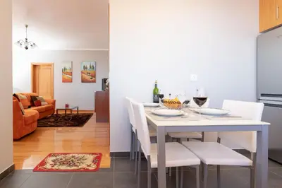 a dining room and living room with a white table and chairs at Apartment Laranjeiras in Calheta