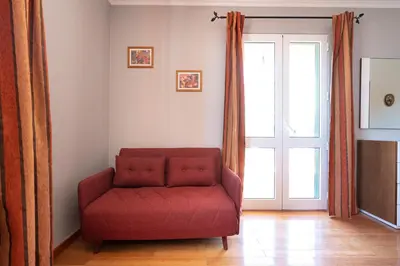 a red couch in a living room with a window at Apartment Laranjeiras in Calheta