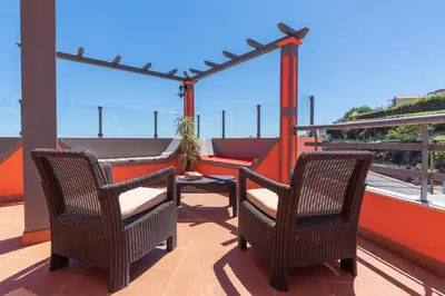 two chairs and a table on a balcony at Apartment Laranjeiras in Calheta