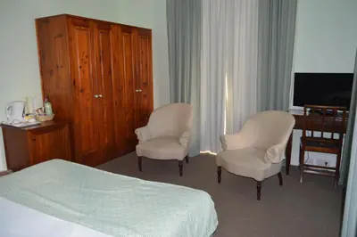 a bedroom with two chairs and a bed and a television at Quinta Da Penha De Franca in Funchal