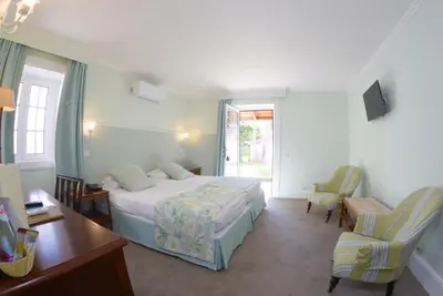 a bedroom with a bed and a desk and chairs at Quinta Da Penha De Franca in Funchal