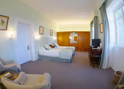 a hotel room with two beds and a desk at Quinta Da Penha De Franca in Funchal