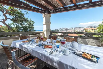 a table with plates of food on top of a balcony at ARTS IN Hotel Conde Carvalhal in Funchal