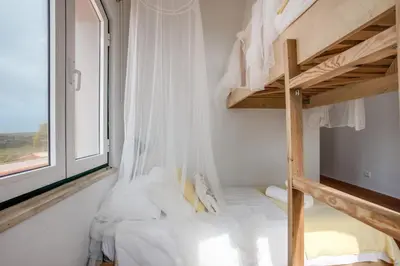 a bedroom with two beds with mosquito nets at Casa das Furnas - Eco Home in Vila do Bispo