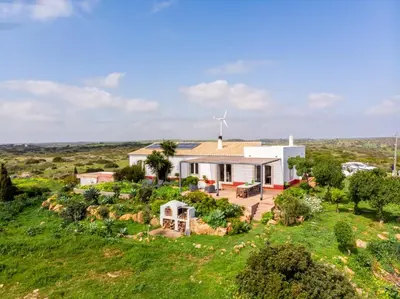 an aerial view of a house on a hill next to the ocean at Casa das Furnas - Eco Home in Vila do Bispo