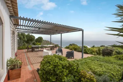 a pergola on a patio with a table and chairs at Casa das Furnas - Eco Home in Vila do Bispo