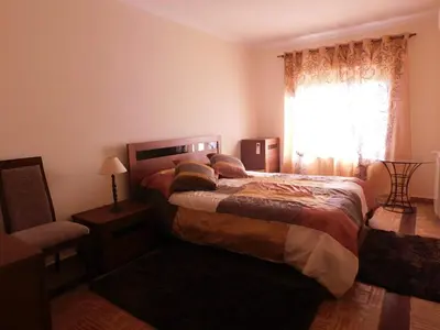 a bedroom with a bed and a window and a chair at Vista da Atlantica in Luz