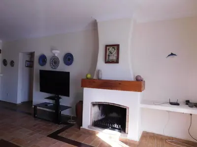 a living room with a fireplace with a flat screen tv at Vista da Atlantica in Luz