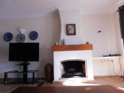 a living room with a fireplace and a tv at Vista da Atlantica in Luz
