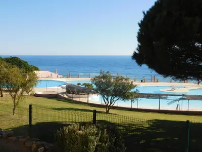 a swimming pool with the ocean in the background at Vista da Atlantica in Luz
