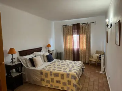 a bedroom with a bed and a chair and a window at Dream Executive Apartments in Luz
