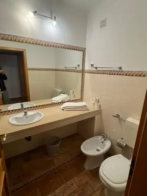a bathroom with a sink and a toilet and a mirror at Dream Executive Apartments in Luz