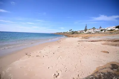 a beach with footprints in the sand and the ocean at Luz Beach Ocean Front Apartment in Luz