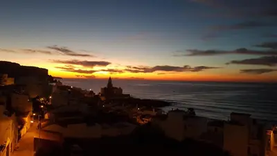 a sunset over a city with the ocean at Luz Beach Ocean Front Apartment in Luz