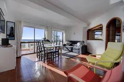 a living room with a table and chairs at Luz Beach Ocean Front Apartment in Luz