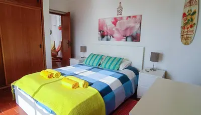 a bedroom with a bed with yellow and blue at Luz Beach Ocean Front Apartment in Luz