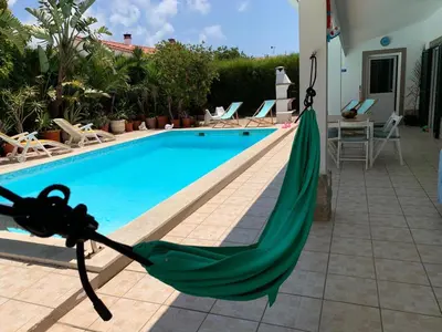 a hammock is tied to the side of a swimming pool at Holiday villa with pool near the ocean, fast internet, Aljezur in Aljezur