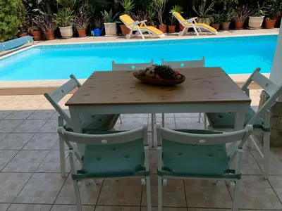a wooden table with chairs and a bowl of fruit on it at Holiday villa with pool near the ocean, fast internet, Aljezur in Aljezur