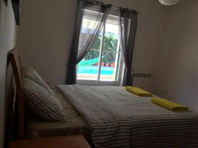 a bed with two yellow pillows sitting next to a window at Holiday villa with pool near the ocean, fast internet, Aljezur in Aljezur