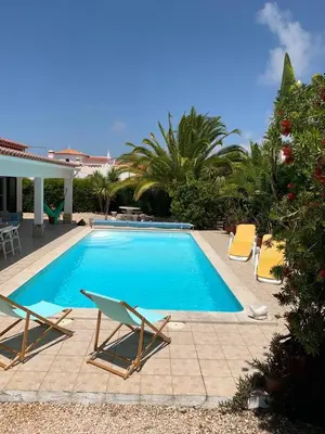 a swimming pool with two lounge chairs next to it at Holiday villa with pool near the ocean, fast internet, Aljezur in Aljezur