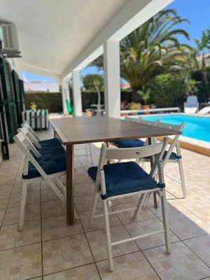 a wooden table with two chairs and a pool at Holiday villa with pool near the ocean, fast internet, Aljezur in Aljezur