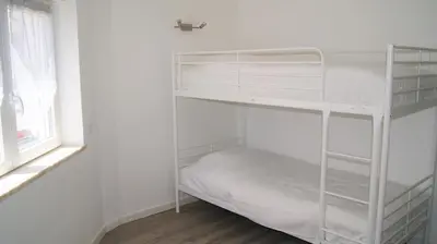 a white bunk bed in a white room with a window at Apartamento Próximo da Praia in Luz