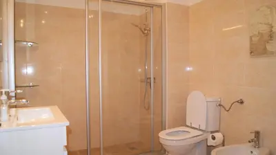 a bathroom with a shower and a toilet and a sink at Apartamento Próximo da Praia in Luz