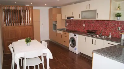 a kitchen with a white table and white chairs at Apartamento Próximo da Praia in Luz
