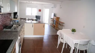 a kitchen and dining room with a table and a counter at Apartamento Próximo da Praia in Luz