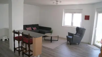 a living room with a couch and a table and chairs at Apartamento Próximo da Praia in Luz