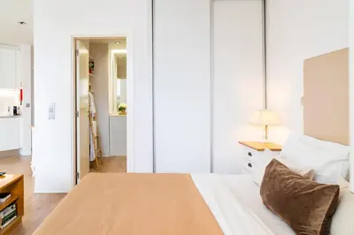 a bedroom with white walls and a bed with a lamp at Golden escape in Funchal in Funchal