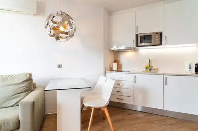 a white kitchen with a table and a couch at Golden escape in Funchal in Funchal