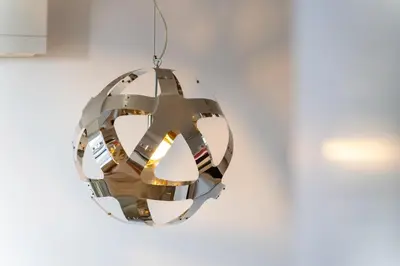 a circular chandelier hanging on a white wall at Golden escape in Funchal in Funchal