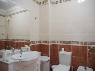 a bathroom with a white toilet and a sink at Large Penthouse Near Porto de Mos Beach With Magnificent Views In Lagos in Lagos