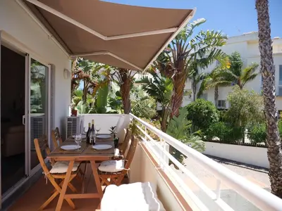 a patio with a table and chairs on a balcony at Large Penthouse Near Porto de Mos Beach With Magnificent Views In Lagos in Lagos