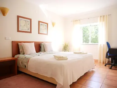 a bedroom with a large white bed with a window at Large Penthouse Near Porto de Mos Beach With Magnificent Views In Lagos in Lagos
