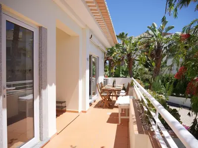 a balcony of a house with a table and chairs at Large Penthouse Near Porto de Mos Beach With Magnificent Views In Lagos in Lagos