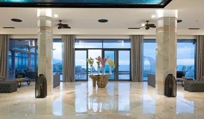a lobby with columns and a vase with flowers in it at Hotel Baia Azul in Funchal