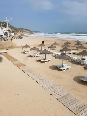 a group of umbrellas and chairs on a beach at Casa Praia Mar in Salema