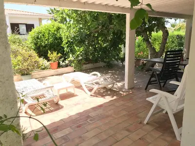 a patio with white chairs and a table and chairs at VIVENDA JOHANNA in Lagos